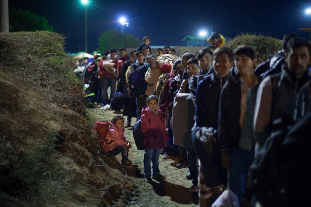 夕暮れ時に長蛇の列を作って待機するアフガニスタン、イラク、シリア・アラブ共和国などからの難民と移住者。クロアチア・セルビア国境のオバトバッツ登録・一時収容センターで【写真：UNICEF/Ashley Gilbertson VII】