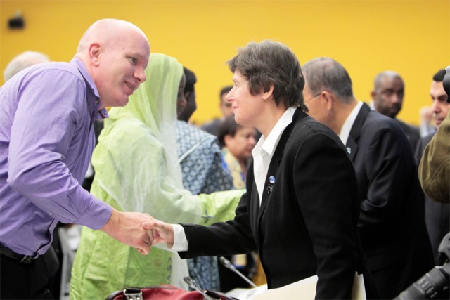 2011年、国連本部で開催された式典で、職務中に命を落とした国連職員の家族と握手を交わすケイン管理担当事務次長（当時）©UN Photo/Rick Bajornas