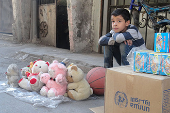 ヤルムーク難民キャンプの通りでおもちゃを売るパレスチナ人の子ども。シリア紛争のため、14万人のパレスチナ難民がキャンプを追われた©UNRWA /Rami Al-Sayyed